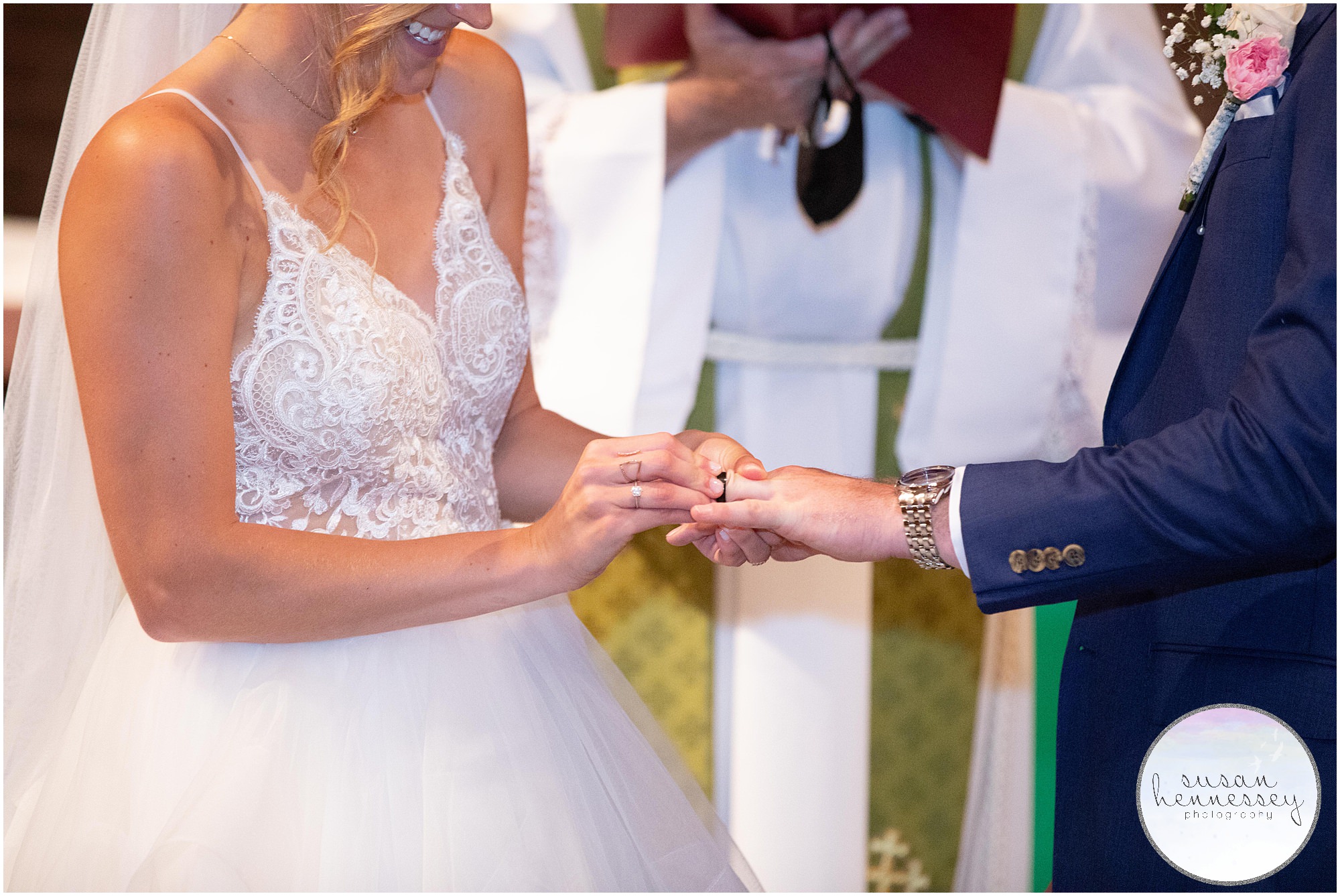 Bride places ring on groom's finger at church ceremony
