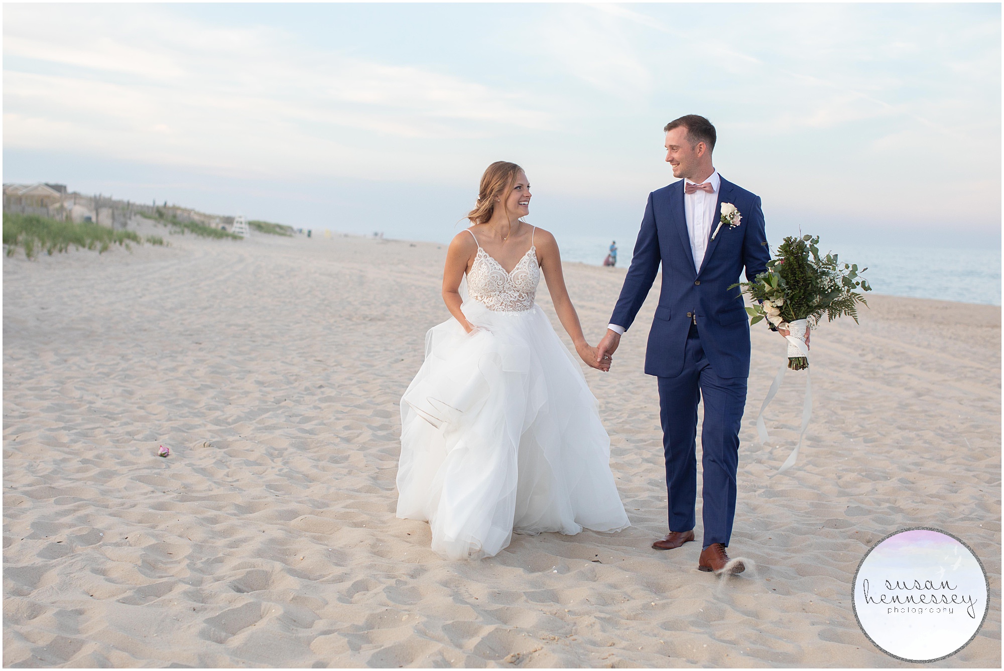 A couple laughs in the sand at Summer microwedding