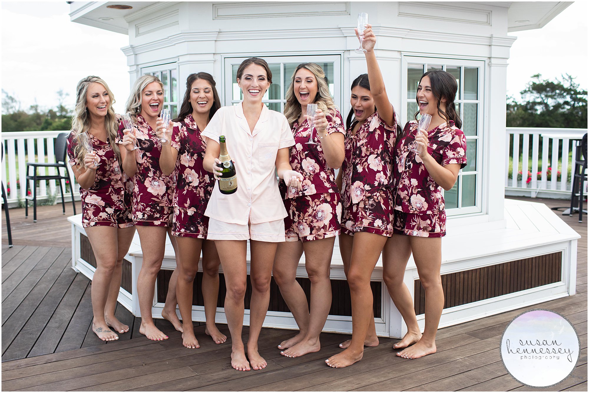 Bride and bridesmaids in matching robes pop champagne at Atlantic City Country Club wedding