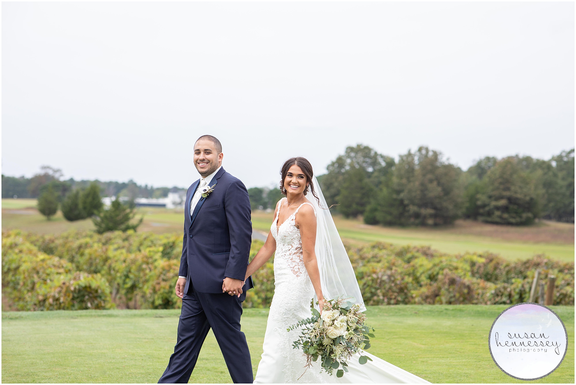 A bride and groom walk across the golf course on their wedding day