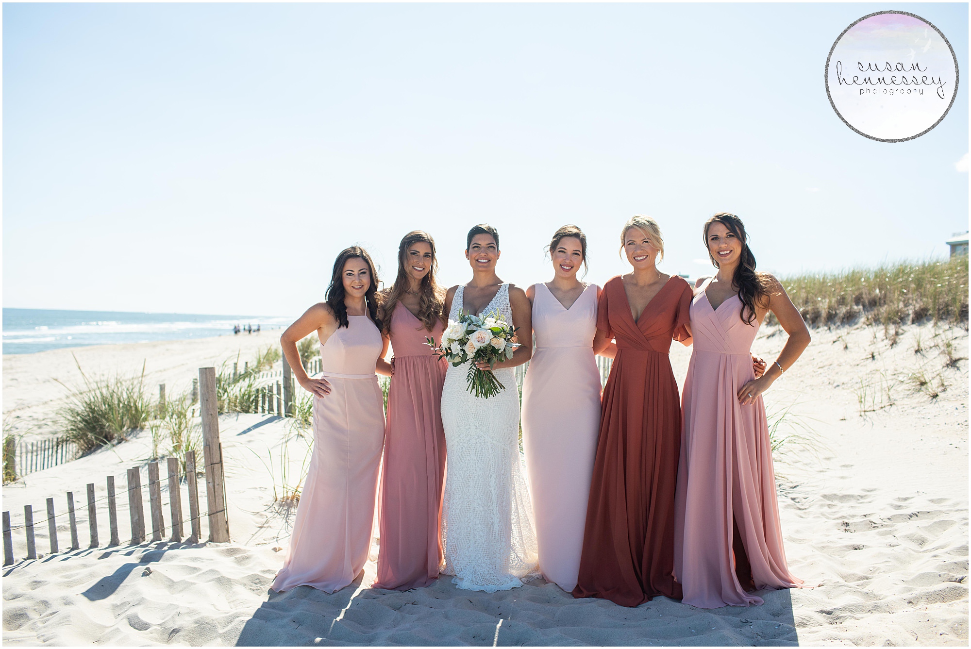 Bride and bridesmaids on beach before ceremony 