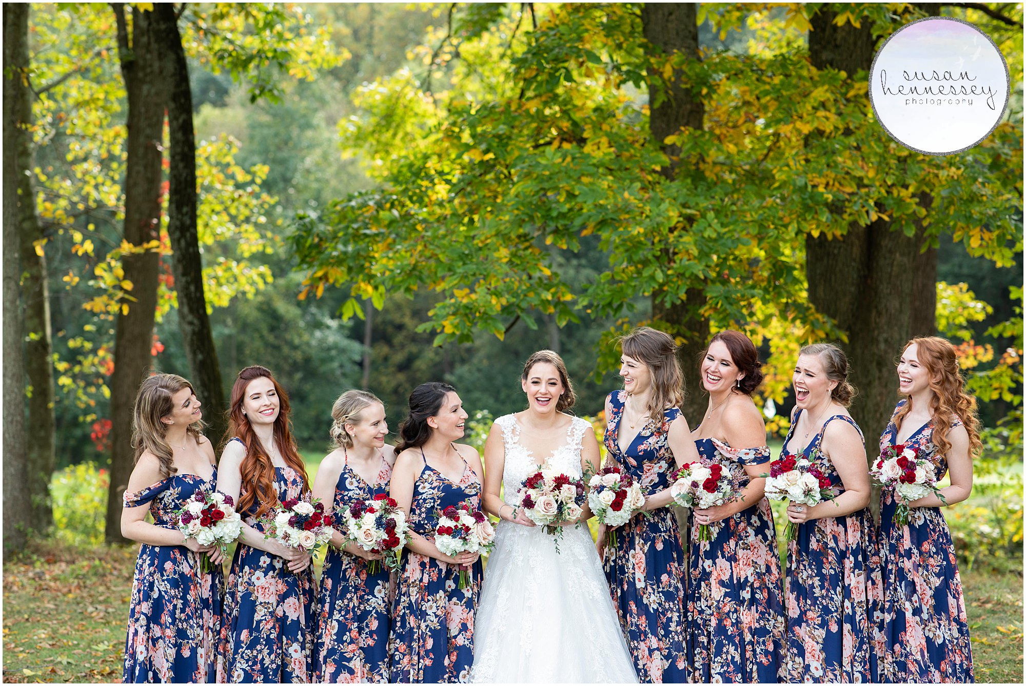 bride and bridesmaids laugh in foliage at Fall Wedding at Old York Country Club