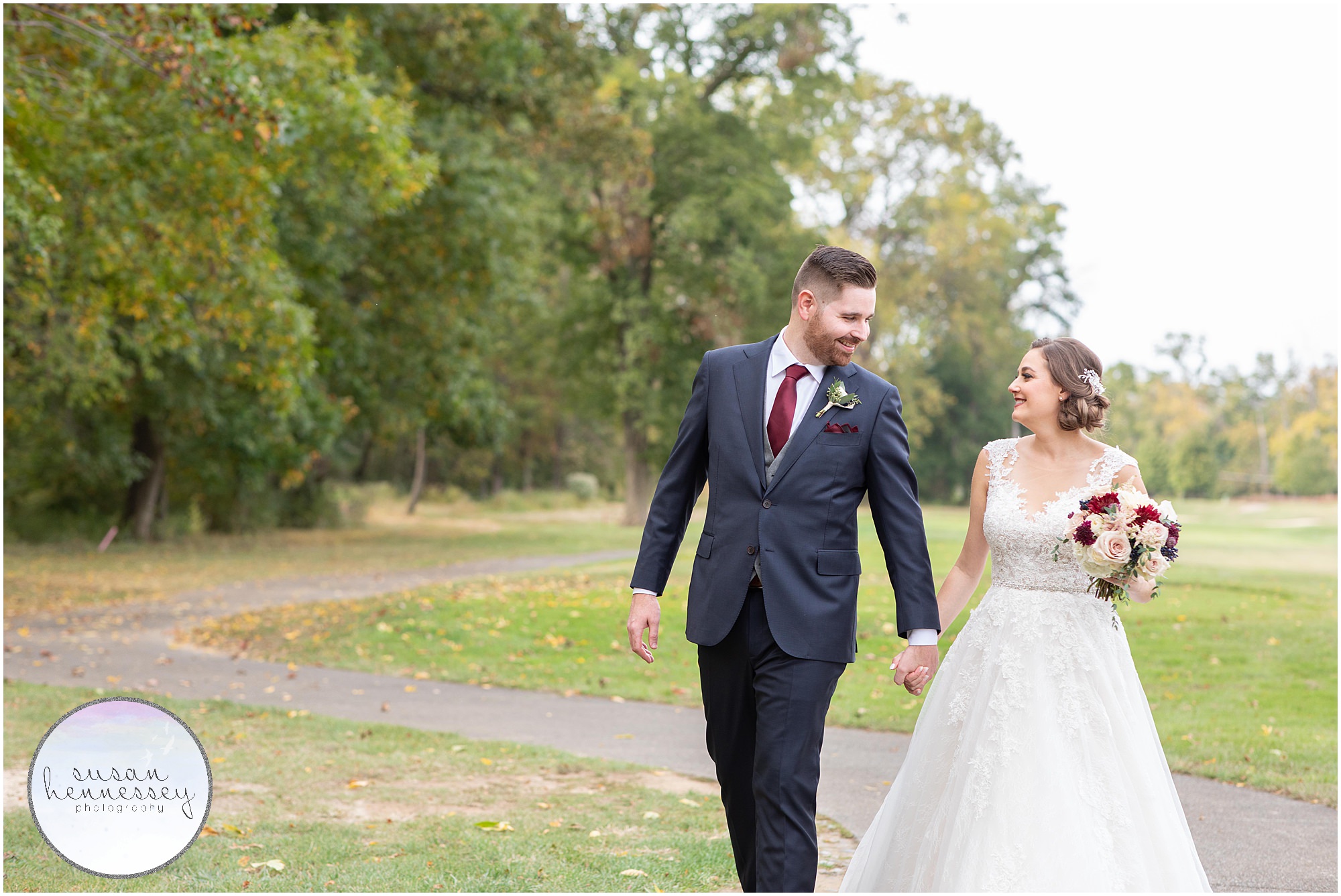 Bride and groom walk on path on golf course at Wedding at Old York Country Club