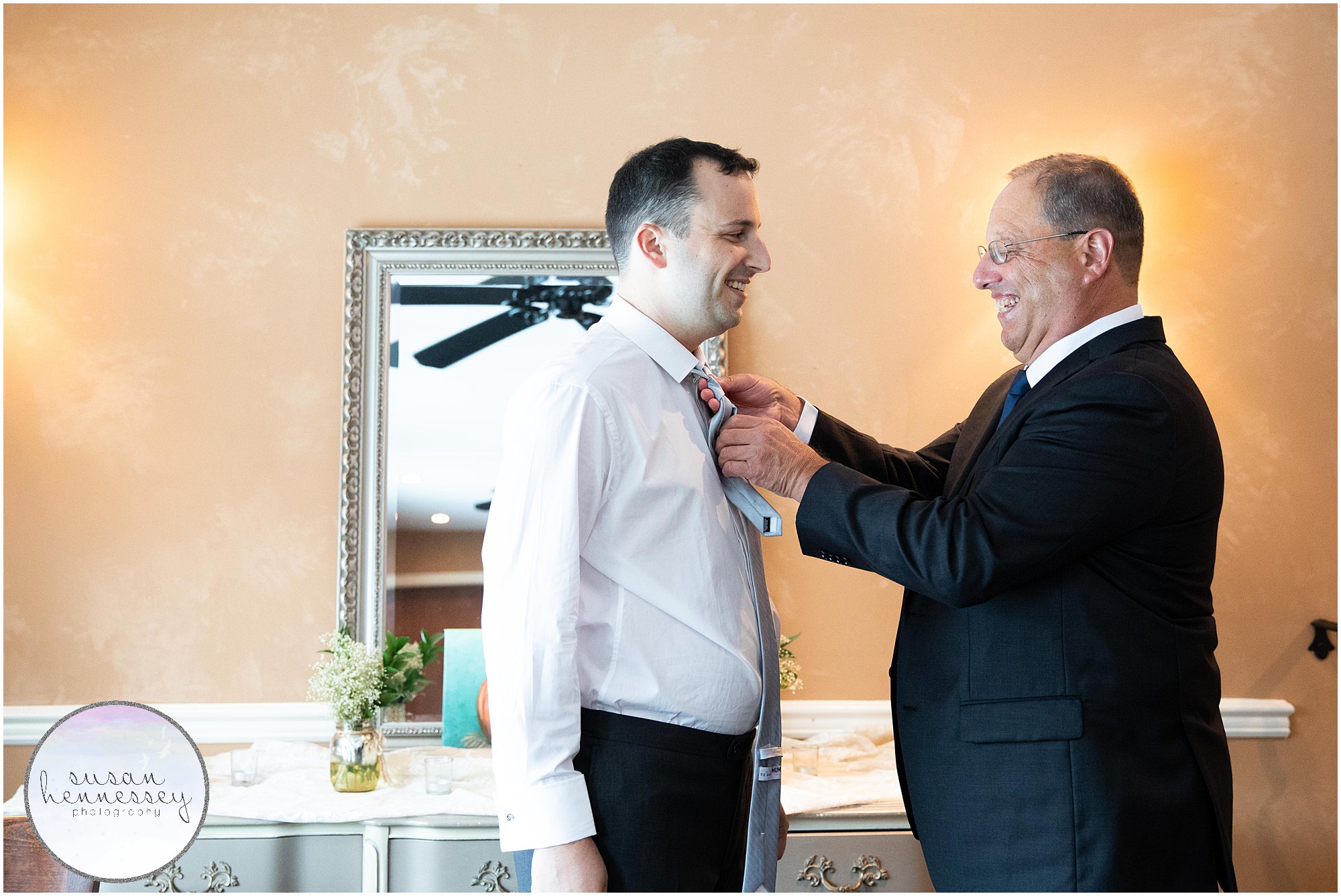 Father helps groom with his tie at Andre's Lakeside Dining Microwedding