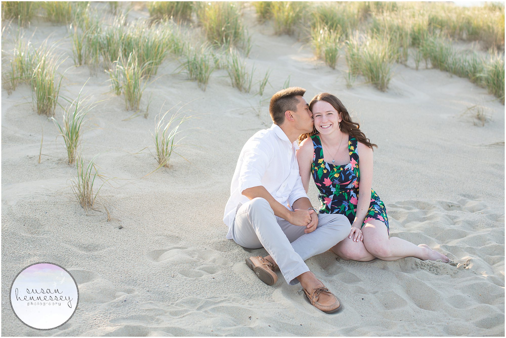 Happily engaged couple sit on the beach at their Bradley Beach Engagement Session