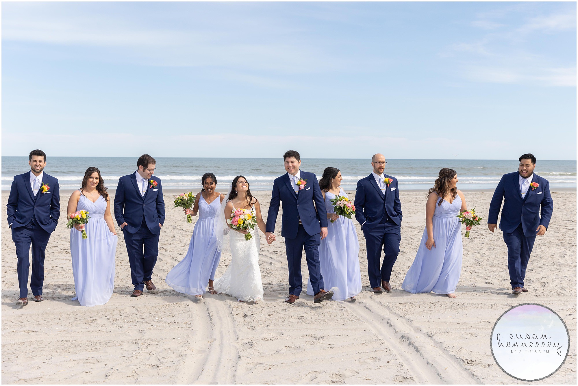Bridal party walk on beach with ocean in the background at ICONA Avalon Wedding