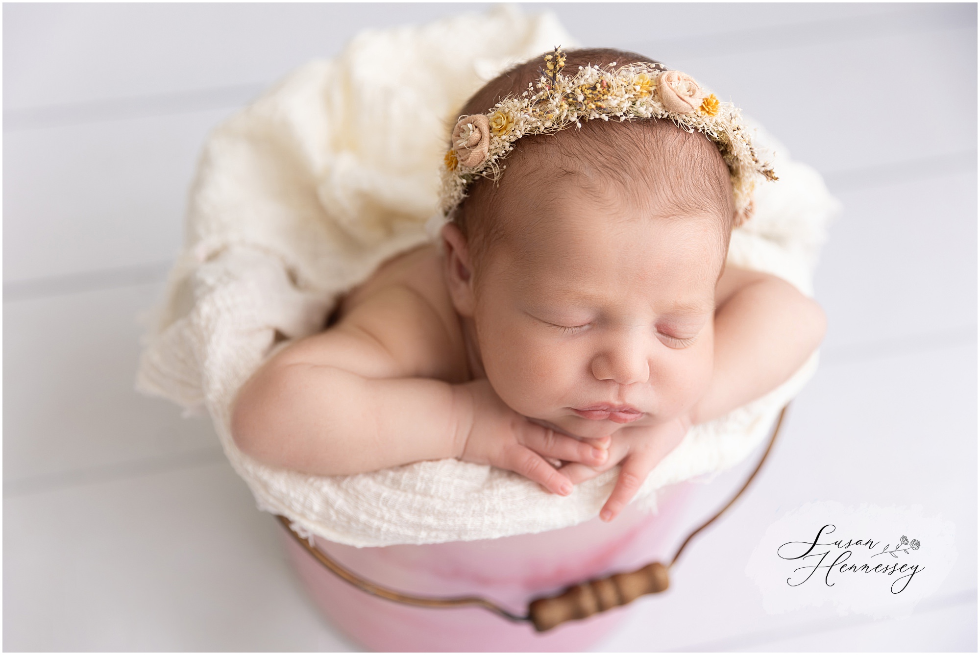 A newborn girl posed in a bucket for her Moorestown newborn session