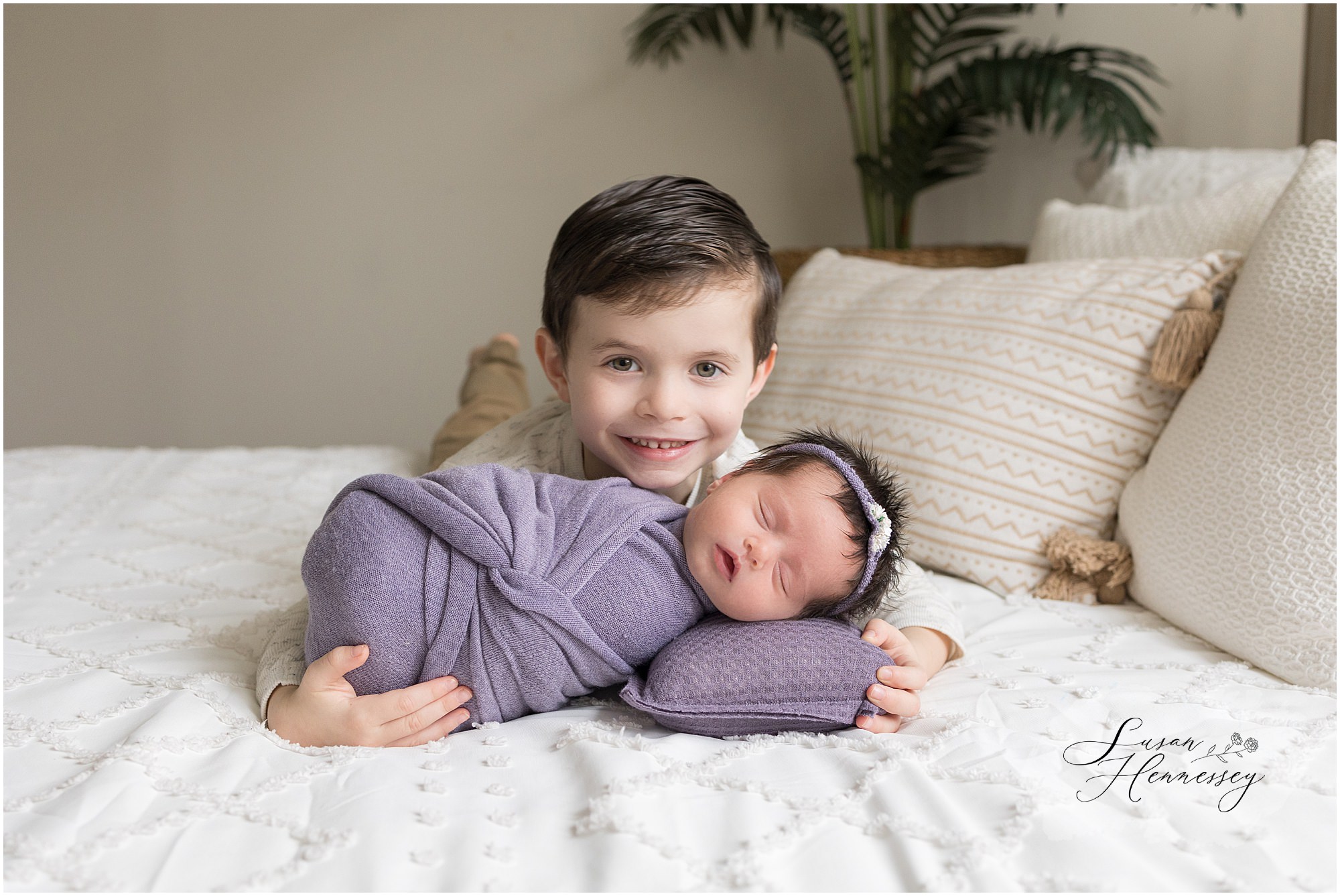 Proud big brother posing with his newborn sister for her in studio newborn session. 