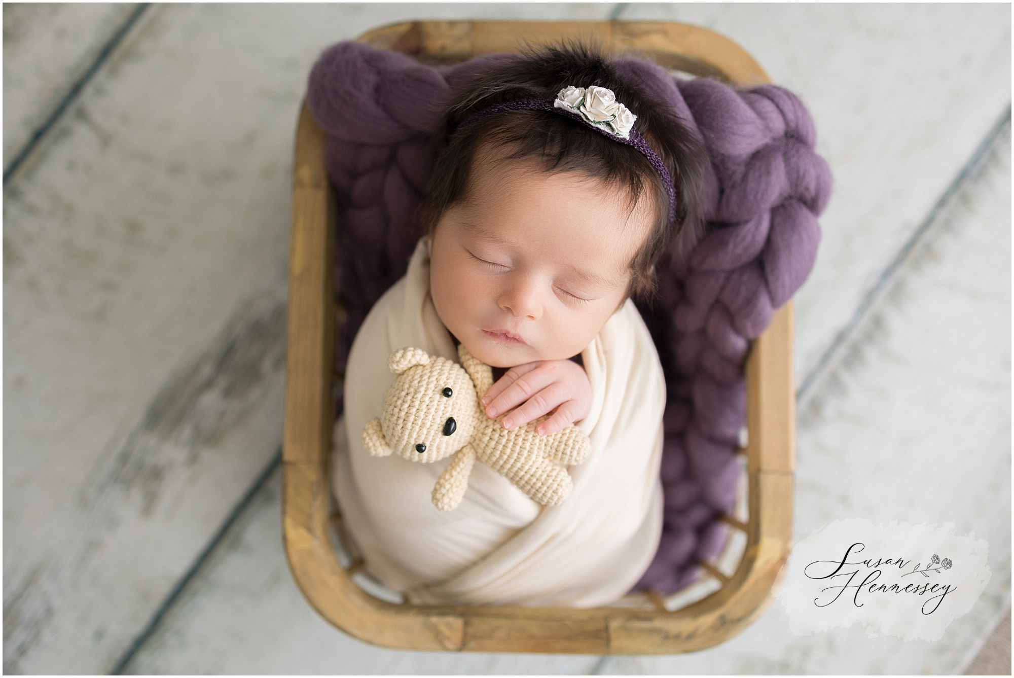 Purple newborn session with a newborn holding a teddy bear. 