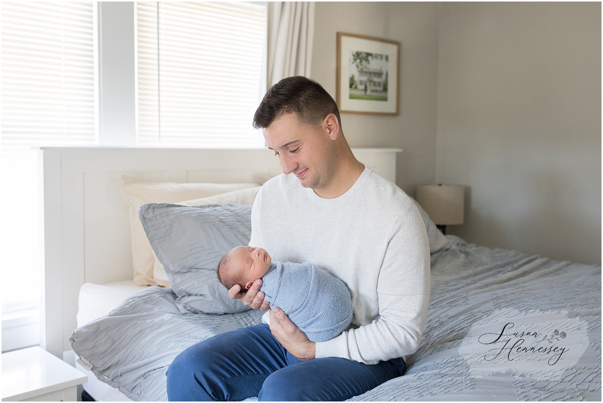 Father holds newborn baby boy during in home newborn session