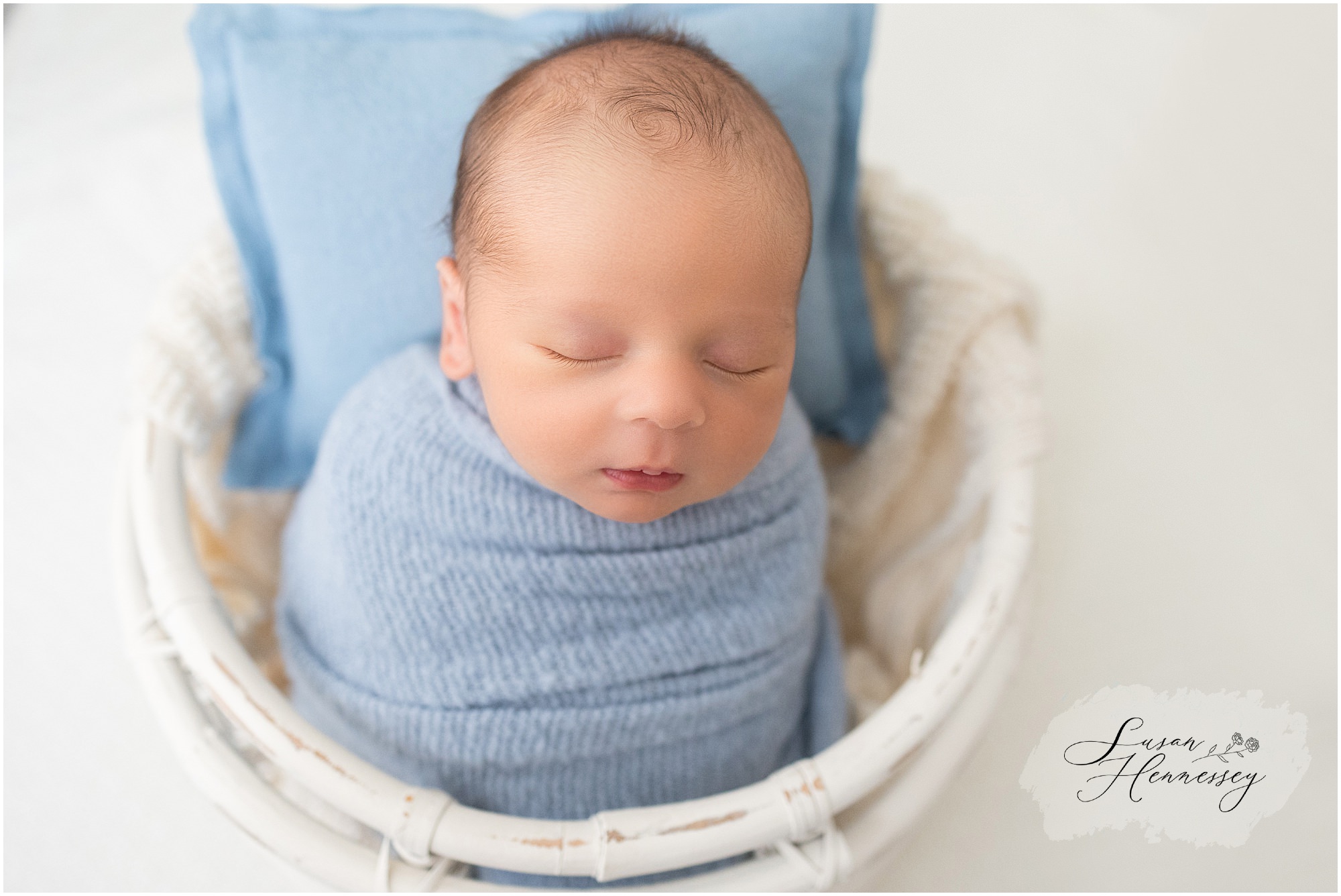 Baby boy in blue during in home newborn session
