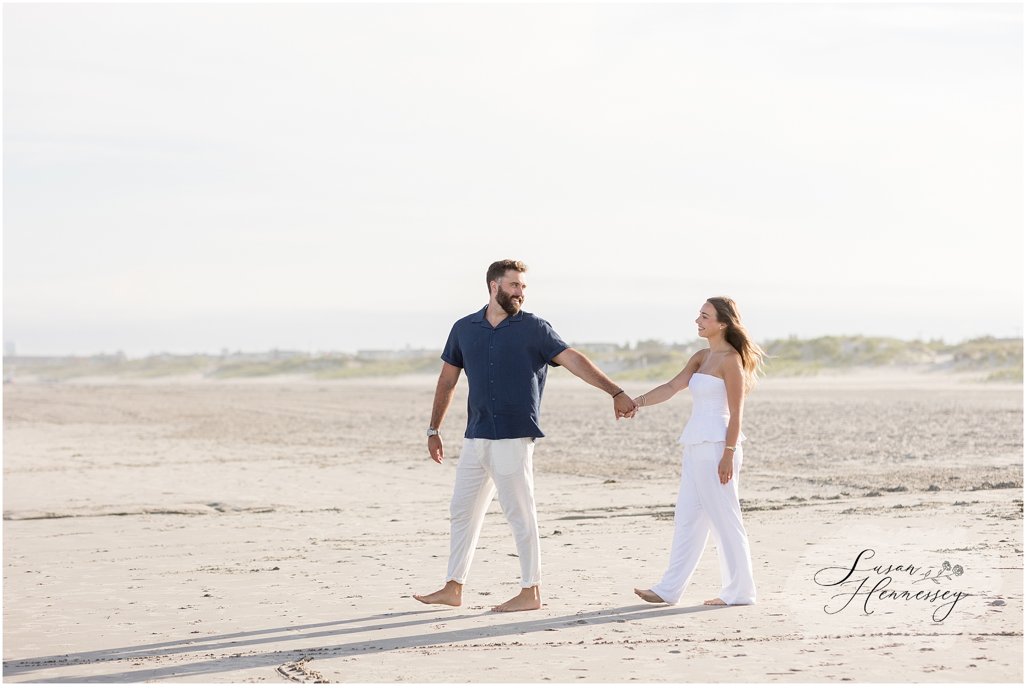 Couple walking along the shoreline during their Jersey Shore engagement session
