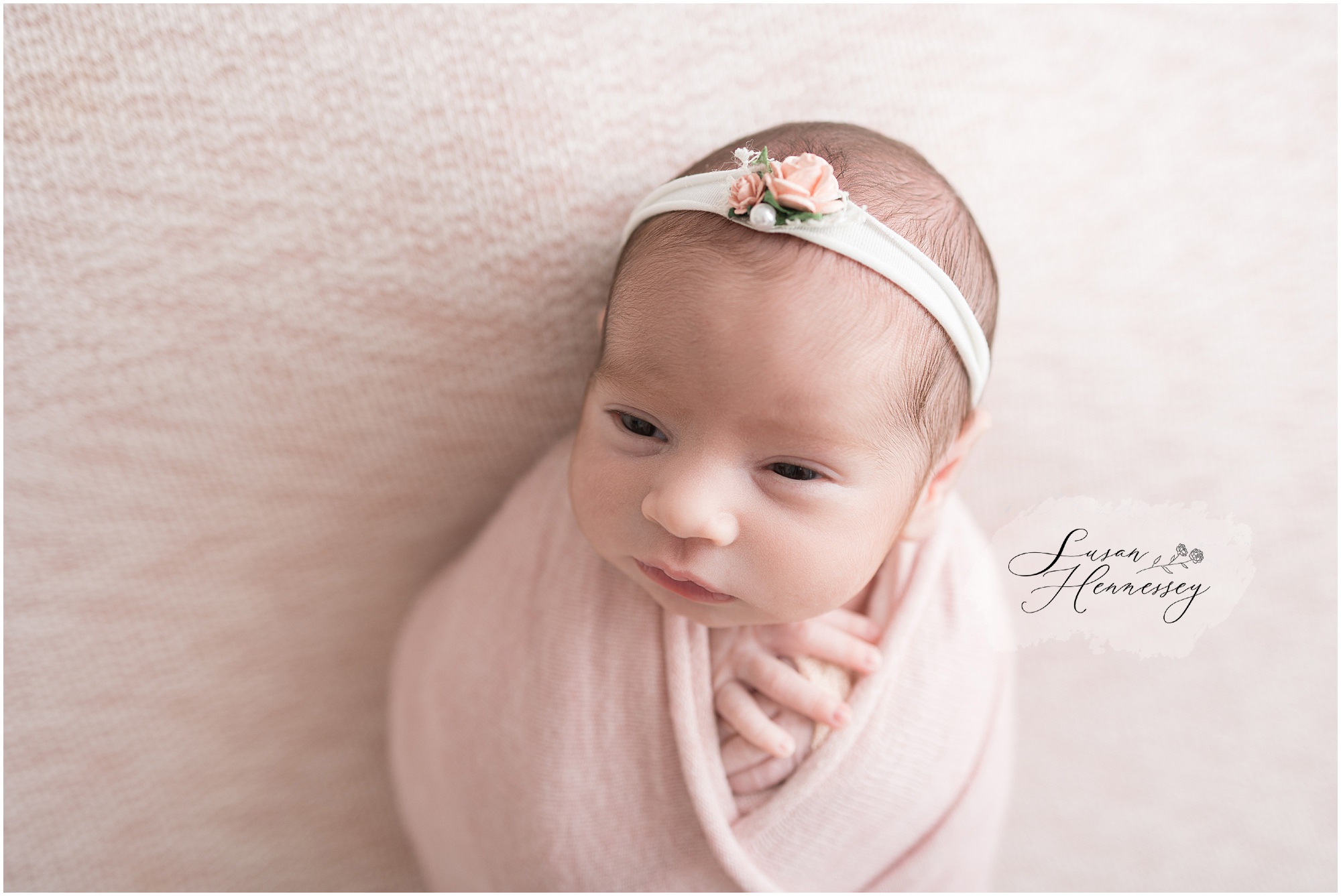Soft pink and peach newborn photography setup for baby girl in studio
