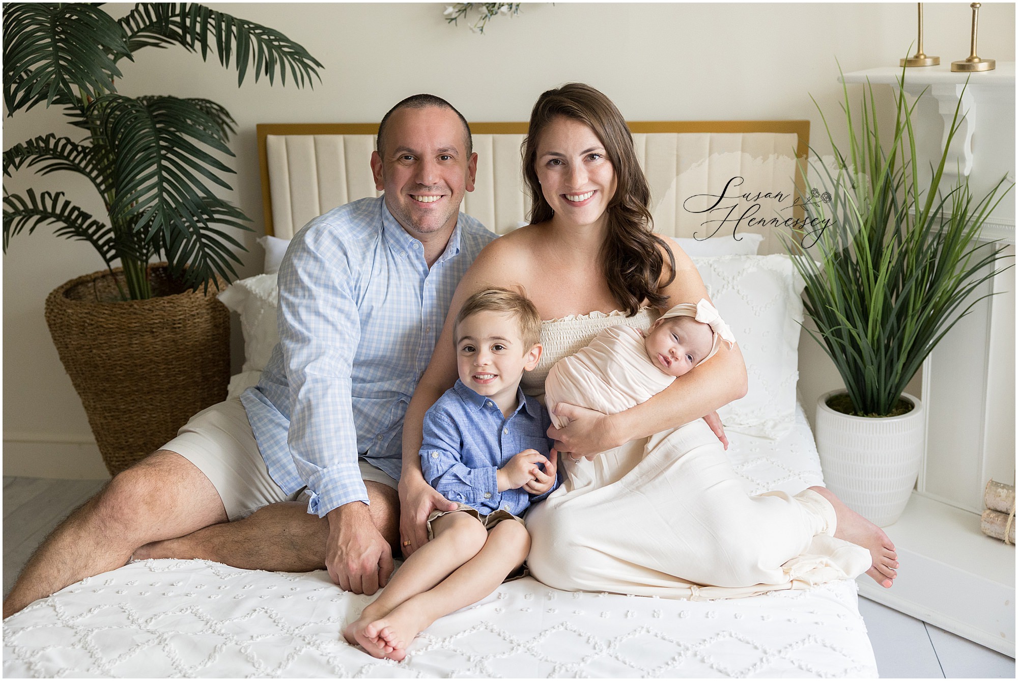 Parents cuddling their newborn baby girl during studio newborn photography session