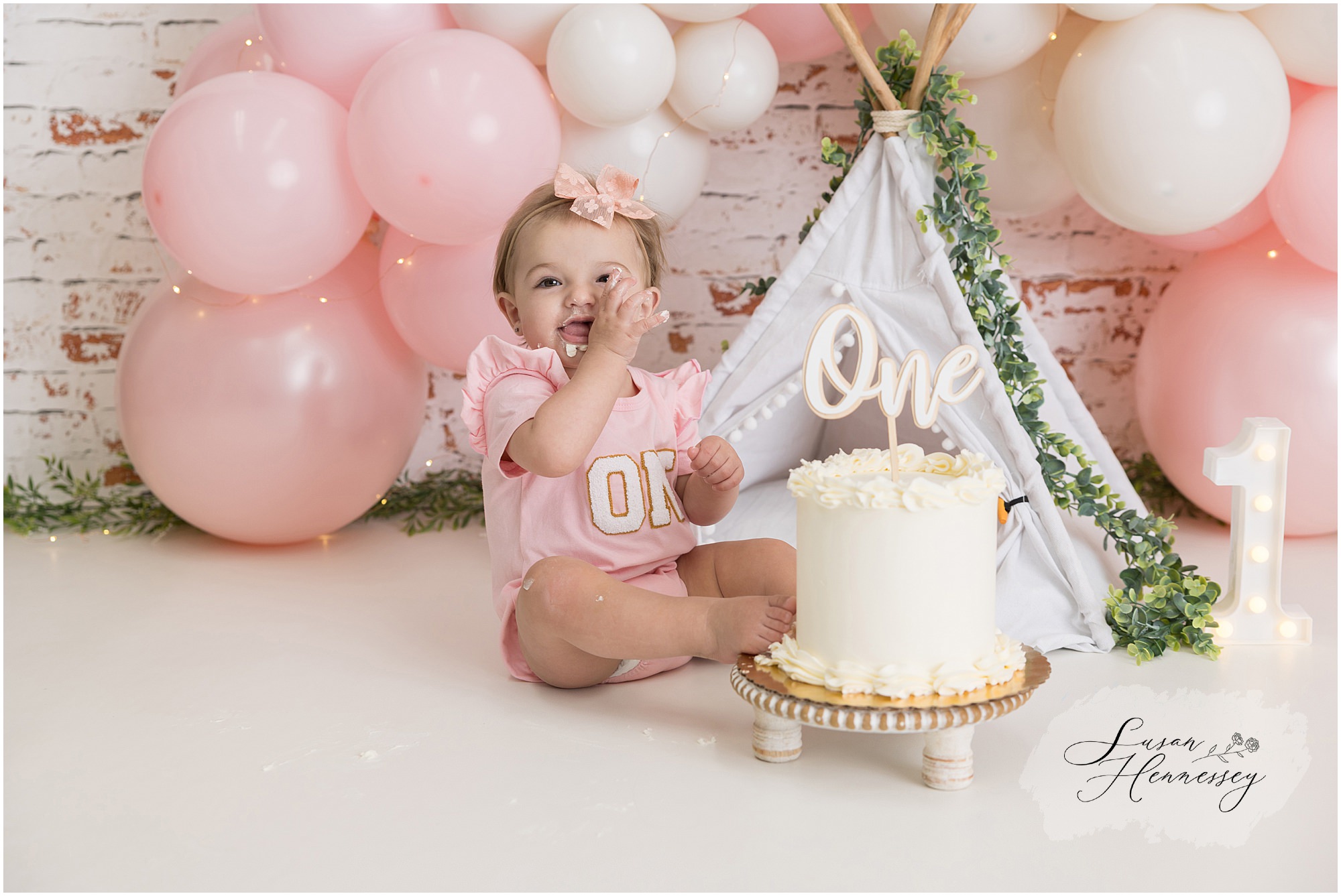 Toddler girl laughing while exploring her cake during a South Jersey cake smash photography session
