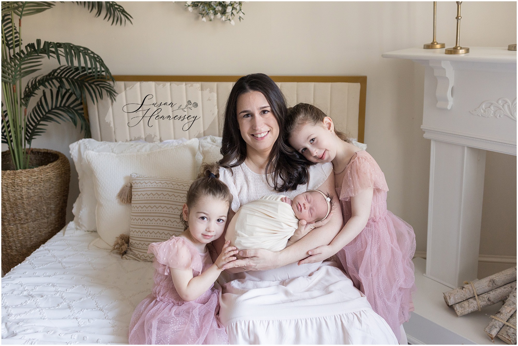 A mother and her three daughters pose at baby girls newborn session in Moorestown NJ