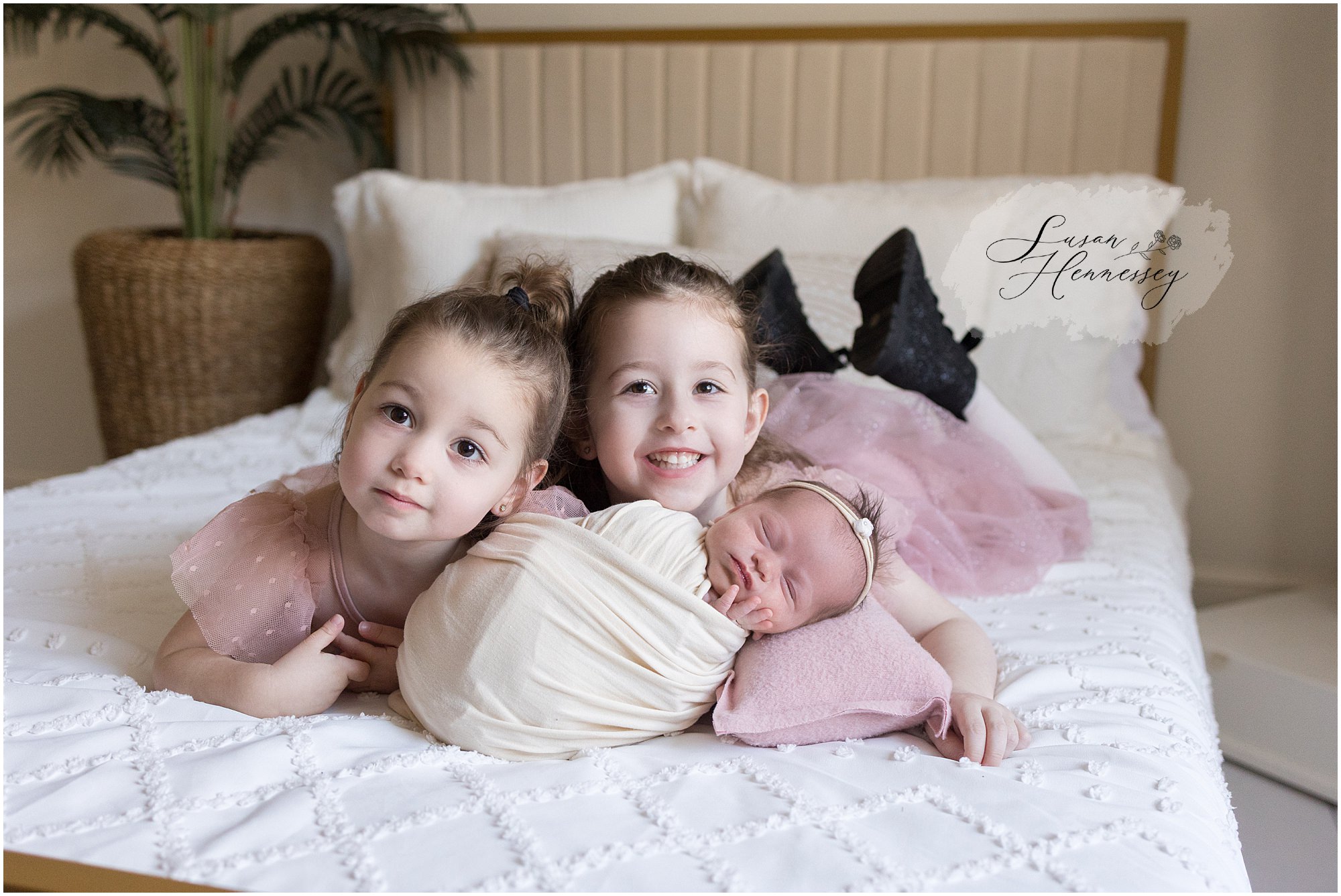 Older sibling holding newborn baby Isabel in South Jersey newborn photography studio