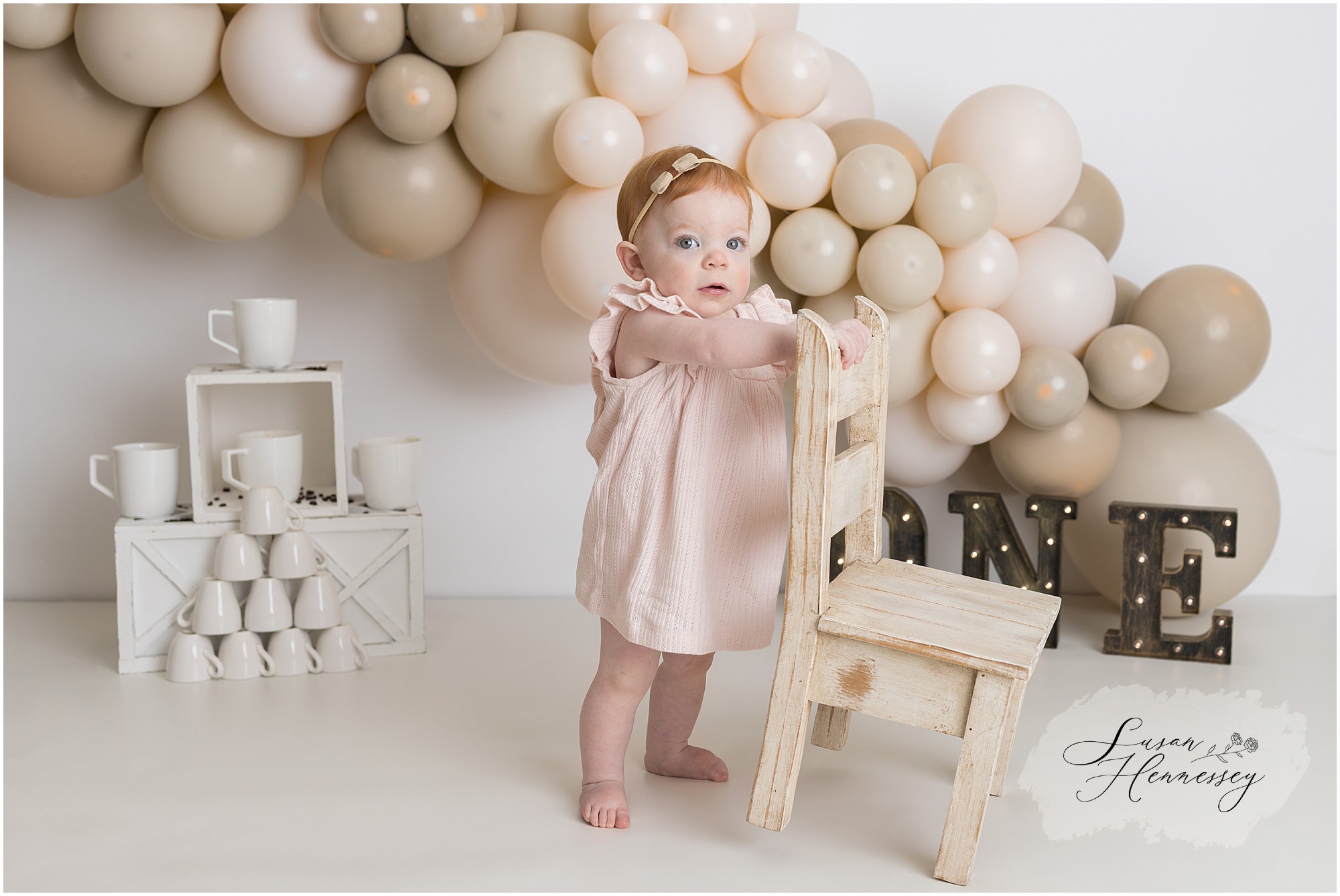 first birthday cake smash session balloon arch neutral pink and tan backdrop