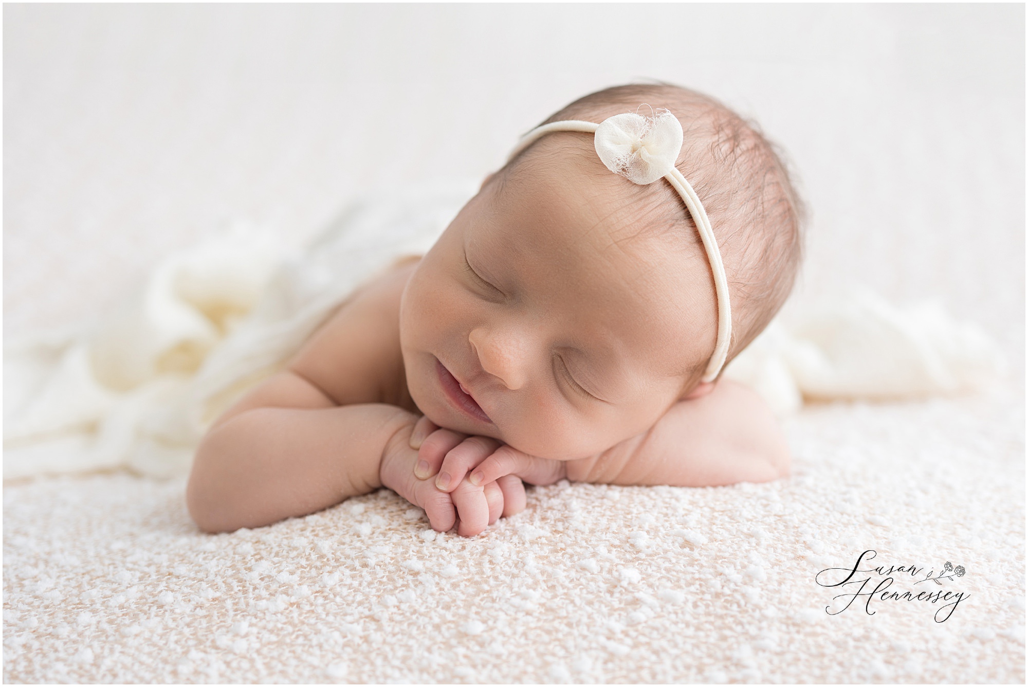 baby girl Claire solo newborn portrait wrapped in cream blanket