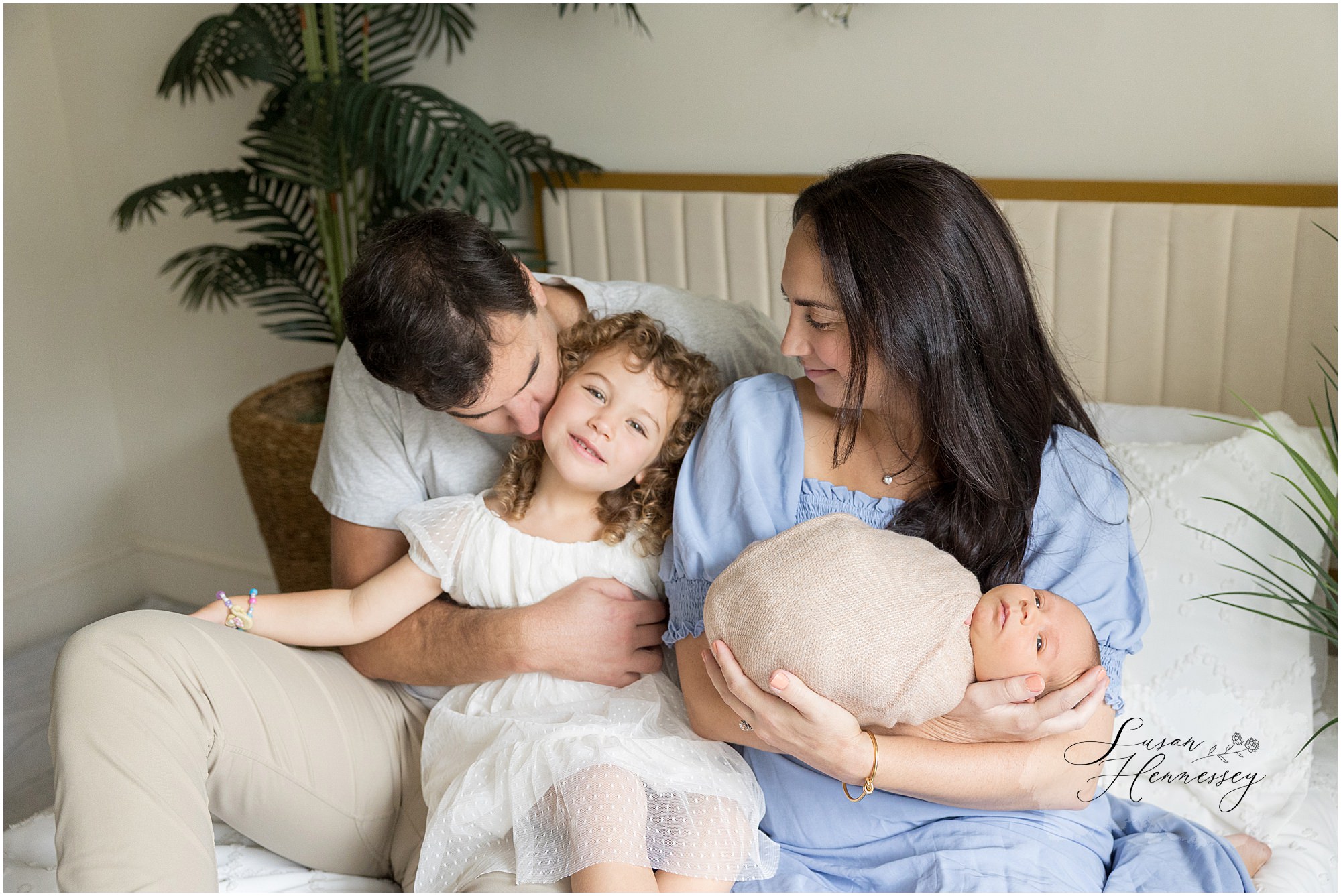 Family of four posing together with newborn baby Carson