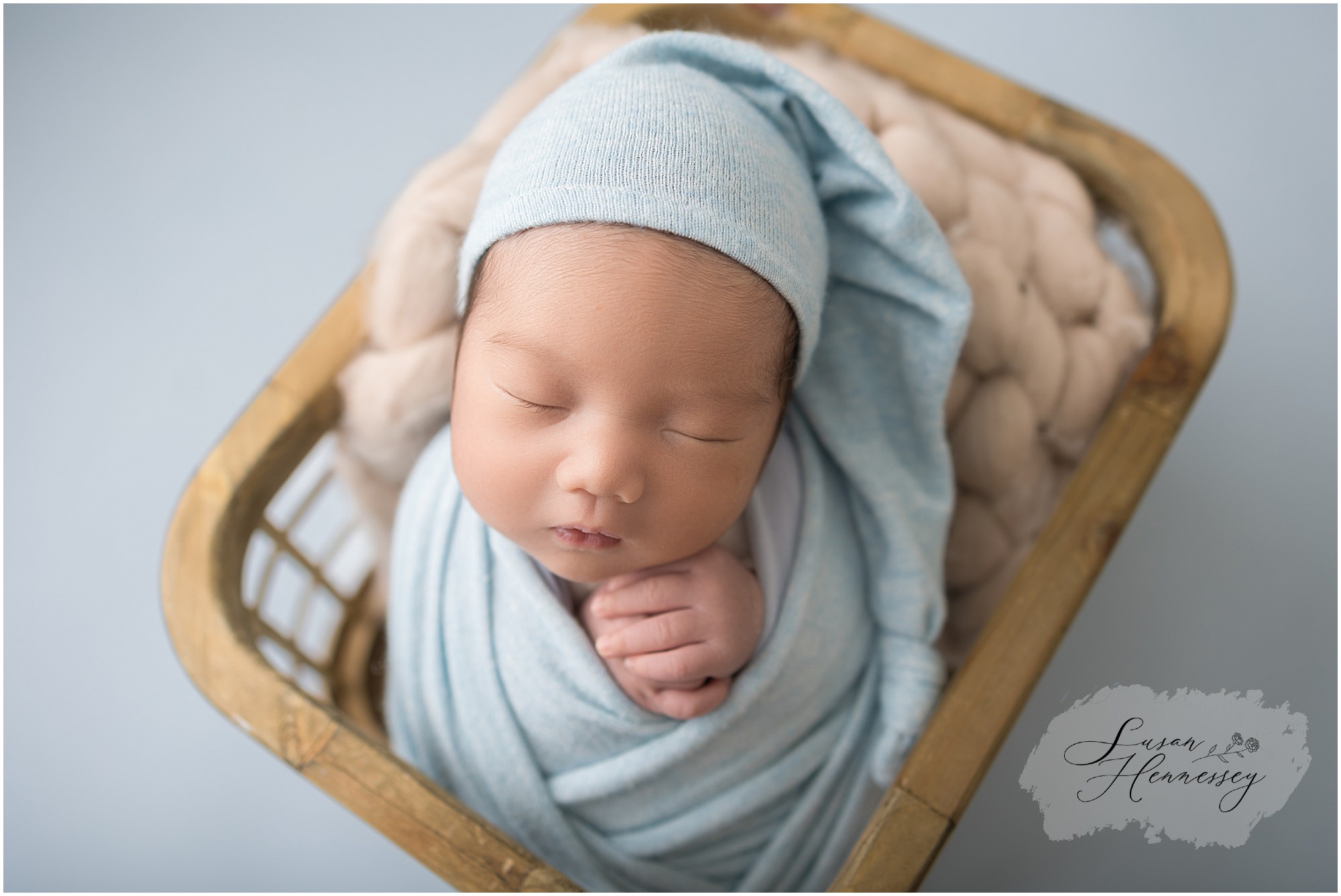 Newborn baby wrapped in blue blanket by Moorestown NJ baby photographer