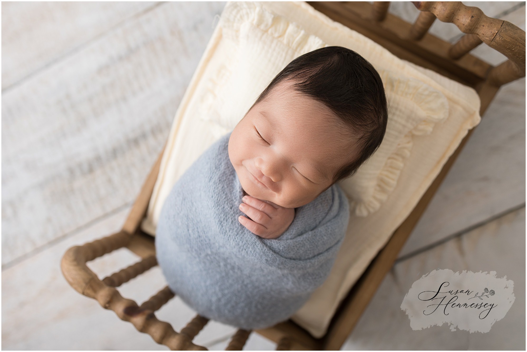 Sleeping newborn boy in blue wrap with cream accents in Moorestown NJ