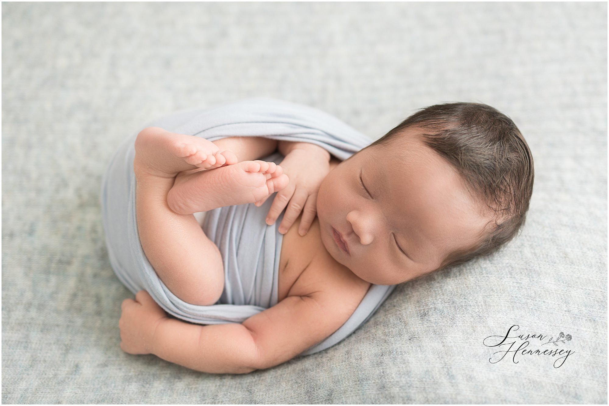 Timeless newborn portrait with blue wraps and neutral textures