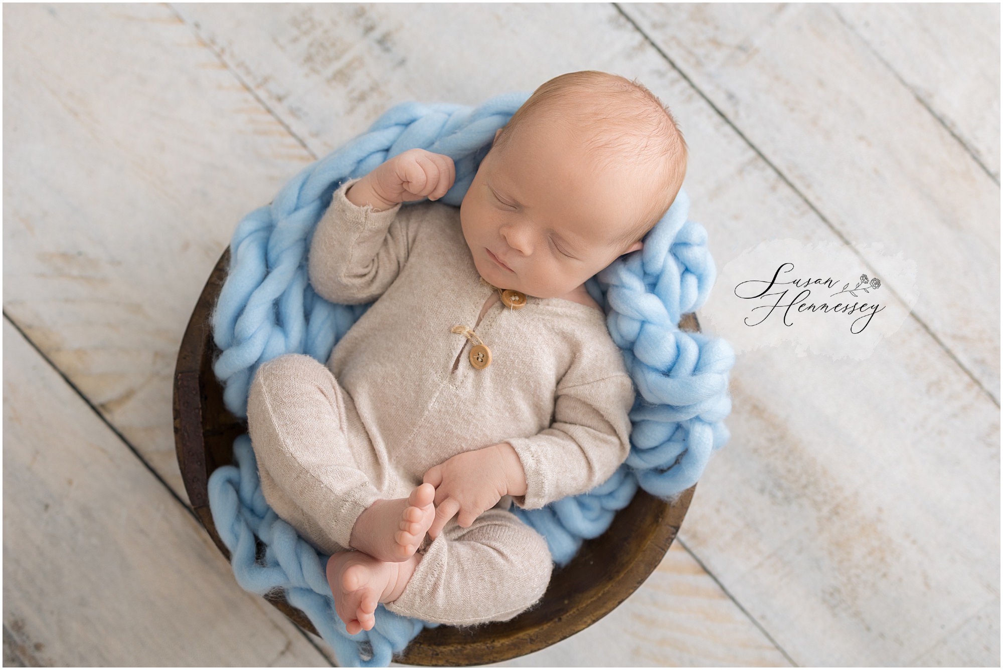 Baby Jack sleeping peacefully in a blue and tan newborn setup at a South Jersey photography studio.