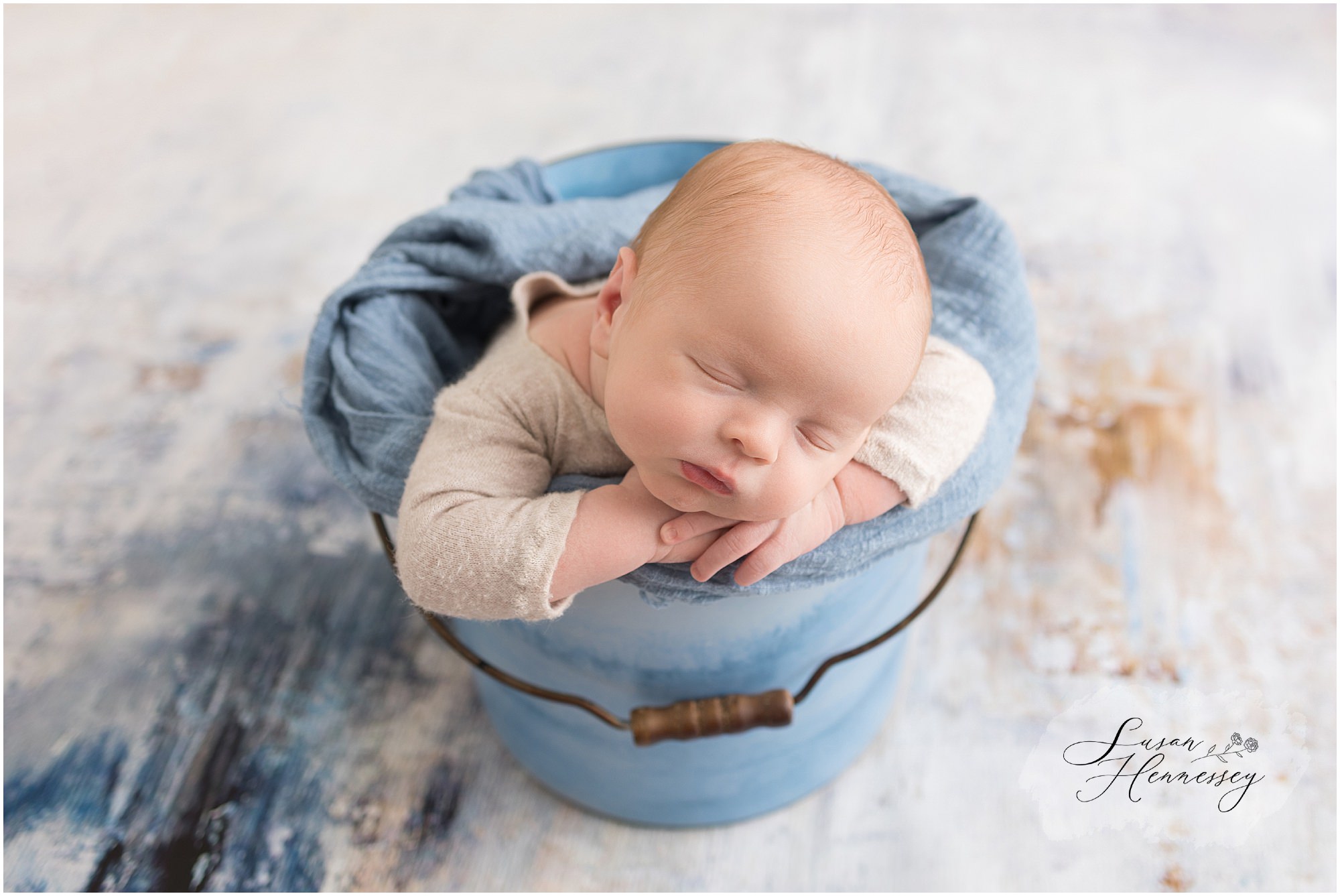 Timeless newborn portrait of baby Jack with blue and tan accents.